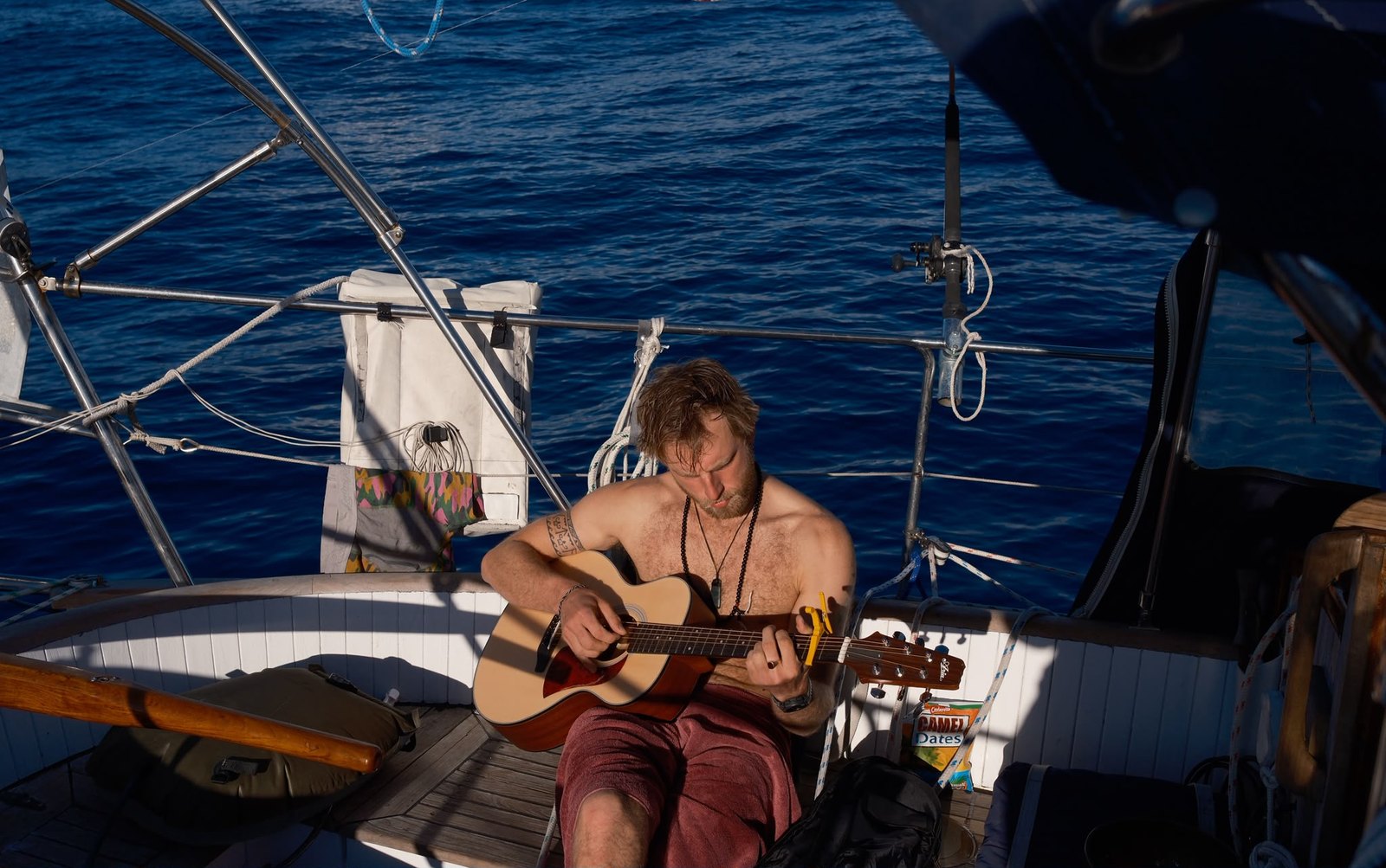 Wiktor playing guitar on deck at sunset, mid-Pacific, during the 33-day crossing from Whangārei to Tahiti